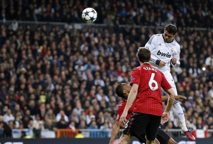 Lompatan Ronaldo Real Madrid's Portuguese forward Cristiano Ronaldo (top) heads the ball to score during the UEFA Champions League round of 16 first leg football match Real Madrid CF vs Manchester United FC at the Santiago Bernabeu stadium in Madrid on February 13, 2013. AFP PHOTO / CESAR MANSO (Photo by CESAR MANSO / AFP)