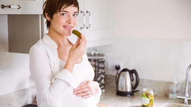 Pregnant woman eating pickles