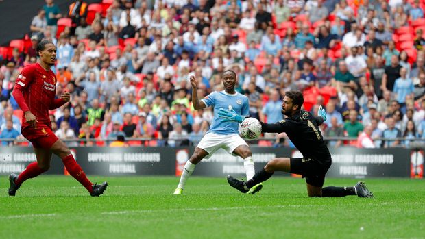Manchester City's Raheem Sterling takes a shot at goal as Liverpool's goalkeeper Alisson Becker tries a save during the English Community Shield soccer match between Liverpool and Manchester City at Wembley stadium in London, Sunday, Aug. 4, 2019. (AP Photo/Kirsty Wigglesworth)