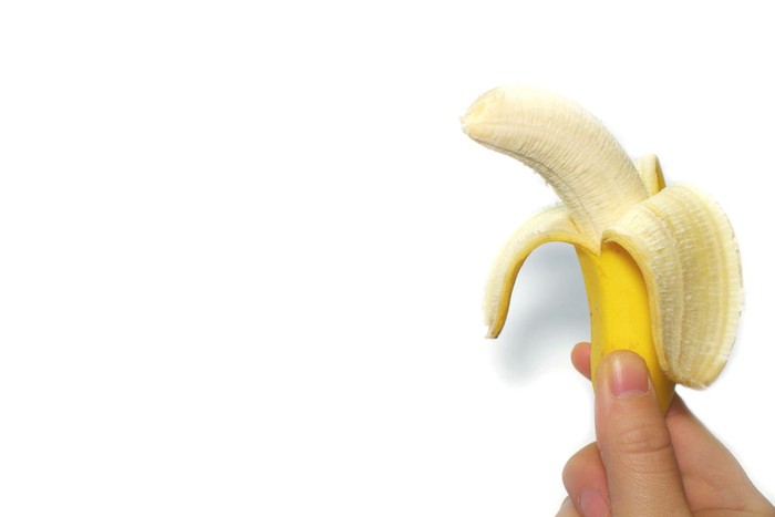 yellow banana and the hand in the white background