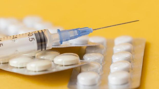 macro photo of tablets and syringe on yellow background. close up image
