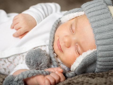 2 months old infant sleeping and smiling in his sleep.