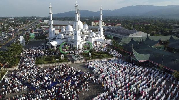 Foto udara sejumlah umat muslim melaksanakan salat Idul Adha, di pelataran parkir Masjid Baiturrahmah, Padang, Sumatera Barat, Minggu (11/8/2019).  Umat muslim di kota itui serentak melaksanakan salat Idul Adha 1440 hijriyah sesuai dengan waktu yang ditetapkan pemerintah pada Minggu 11 Agustus 2022. ANTARA FOTO/Iggoy el Fitra/hp.