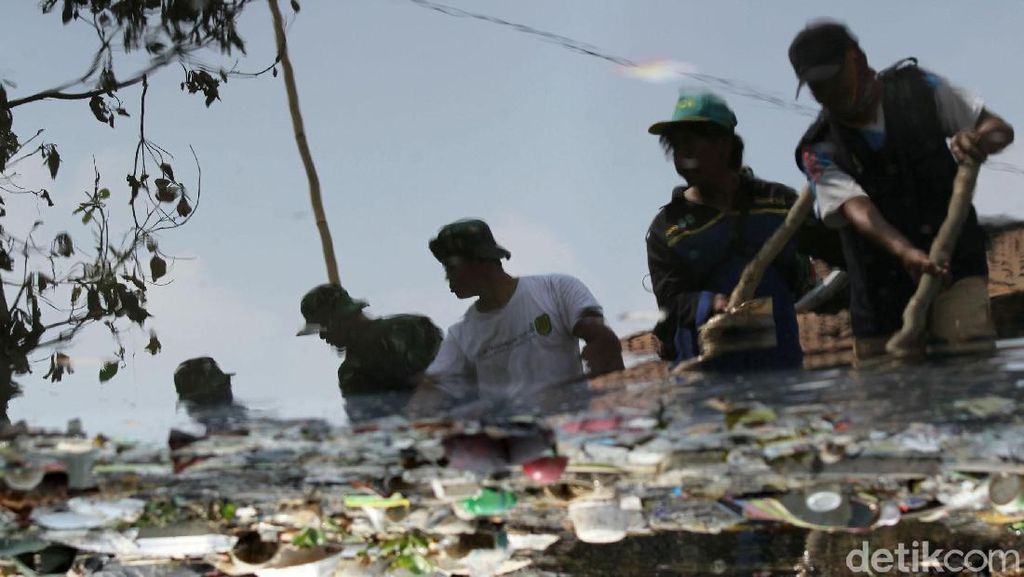 Petugas Berjibaku Membersihkan Sampah di Kali Busa