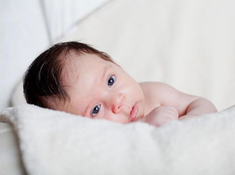 new born baby lie on the bed  open eyes