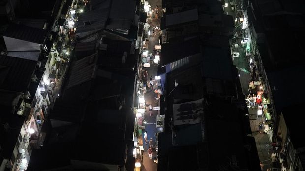 People walk through narrow alleyways clustered with tiny bars and restaurants at the Golden Gai in the Shinjuku district of Tokyo, July 28, 2019. (AP Photo/Jae C. Hong)