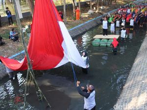 Gelar Upacara di Sungai, Aktivis Lingkungan Kibarkan Bendera Raksasa