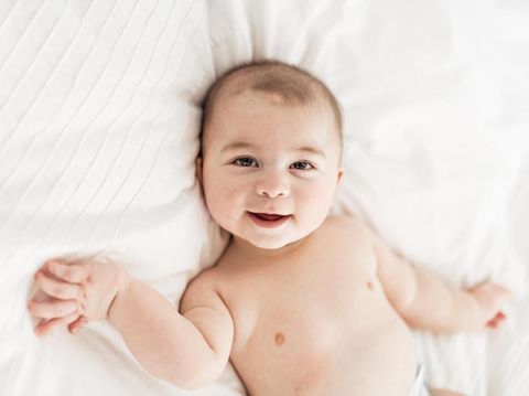 A Portrait of a baby boy on the bed in bedroom