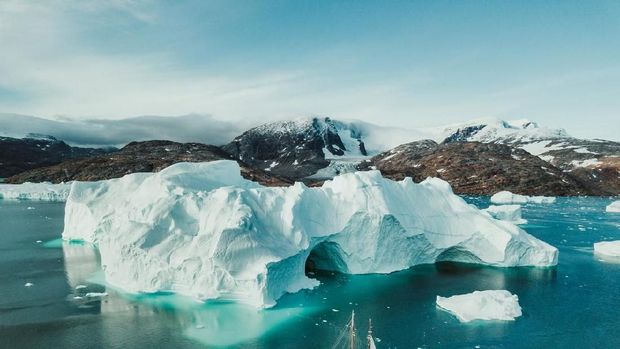 Photo from an expedition with a sailing boat through the beautiful vast landscape of huge icebergs and impressive mountainscapes in East Greenland.
