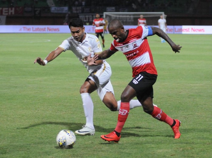 Pesepak bola Madura United (MU) Greg Nwokolo (kanan) berusaha melewati pesepak bola PSS Sleman Derry Rahman Noor (kiri) dalam laga Liga 1 di Stadion Gelora Madura Ratu Pamelingan (SGMRP) Pamekasan, Jawa Timur, Rabu (31/7/2019). PSS Sleman mengalahkan MU dengan skor 1-0. ANTARA FOTO/Saiful Bahri/wsj.