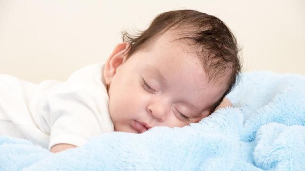 Sweet newborn baby sleeps.  Newborn boy folded handles  in a basket. Copy space