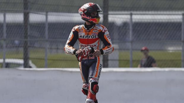 Repsol Honda Team's Spanish rider Marc Marquez walks back after running out of fuel after crossing the finish line in second place in the Moto GP race of the British Grand Prix at Silverstone circuit in Northamptonshire, central England, on August 25, 2019. (Photo by Adrian DENNIS / AFP)