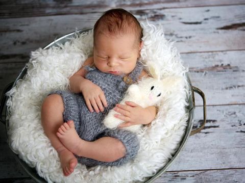 Newborn baby boy, sleeping peacefully in basket, dressed in knitted outfit, chilling out, happy and cute