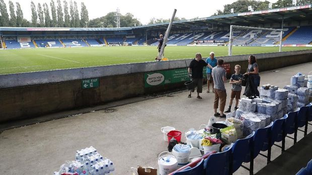 Sukarelawan dan suporter Bury FC membersihkan Stadion Gigg Lane.