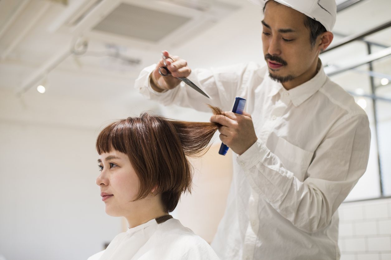 Young woman at a hair salon and cutting hair.