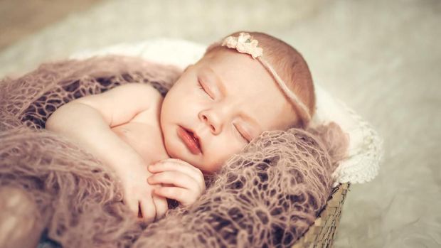 Newborn baby girl sleeping in a basket. Concept shooting newborns, innocence.