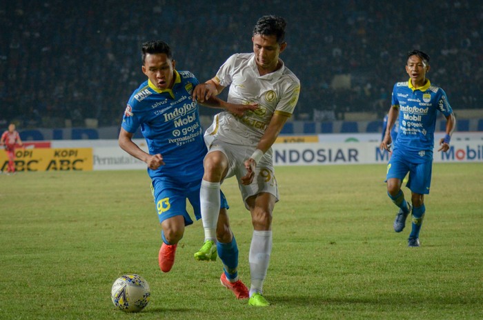 Pesepak bola Persib Bandung Erwin Ramdani (kiri) berebut bola dengan pesepak bola PSS Sleman Dave Mustaine (kedua kanan) pada laga lanjutan liga I di Stadion Si Jalak Harupat, Kabupaten Bandung, Jawa Barat, Jumat (30/8/2019). Persib Bandung menang 1-0. ANTARA FOTO/Raisan Al Farisi
