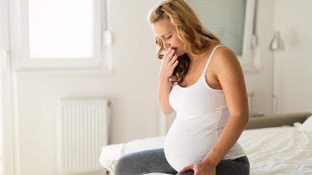 Pregnant woman suffering with nausea in morning