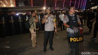 Polisi berusaha menenangkan suporter tuan rumah.