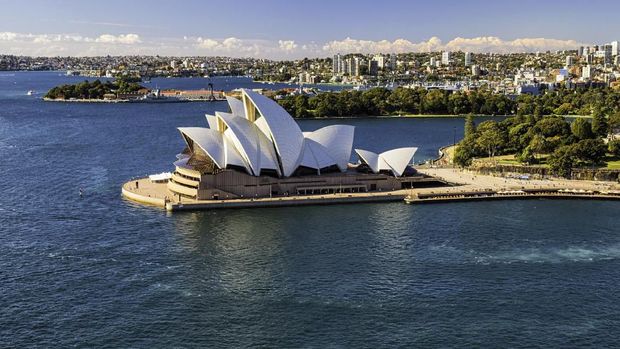 Sydney Australia - August 4, 2017: A clear morning in Sydney, New South Wales, and this is the view looking across Circular Quay towards the iconic shape of the city's Opera House. In the distance we see the Royal Botanic Gardens.