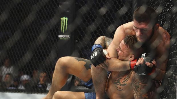 Russian UFC fighter Khabib Nurmagomedov, choke holds UFC fighter Dustin Poirier, of Lafayette, La., during Lightweight title mixed martial arts bout at UFC 242, in Yas Mall in Abu Dhabi, United Arab Emirates, Saturday , Sept.7 2019. (AP Photo/ Mahmoud Khaled)