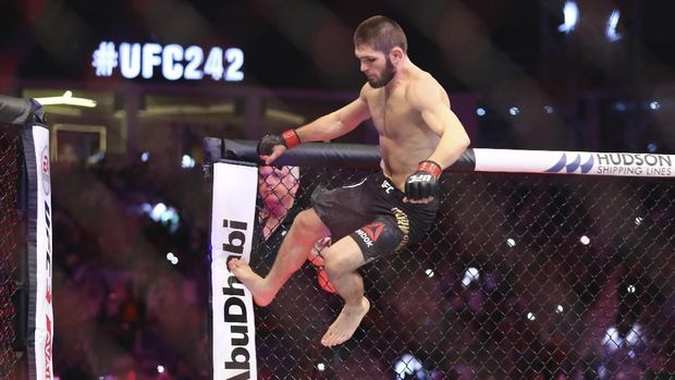 Russian UFC fighter Khabib Nurmagomedov, top, fights with UFC fighter Dustin Poirier, of Lafayette, La., during Lightweight title mixed martial arts bout at UFC 242, in Yas Mall in Abu Dhabi, United Arab Emirates, Saturday , Sept.7 2019. (AP Photo/ Mahmoud Khaled)