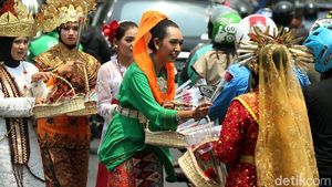 Dukung Revisi UU KPK, Massa Berpakaian Adat Bagikan Bunga