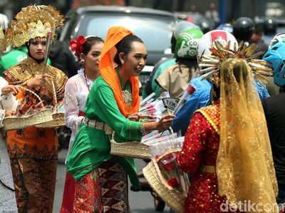 Dukung Revisi UU KPK, Massa Berpakaian Adat Bagikan Bunga