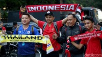 Seorang suporter Timnas Thailand berfoto bersama sejumlah suporter Timnas Indonesia di area sekitar Stadion Utama Gelora Bung Karno, Jakarta.