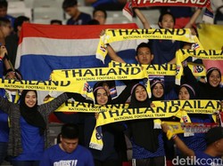 Tampil berhijab, pendukung Thailand membentangkan syal.