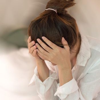 Vertigo illness concept. Woman hands on his head felling headache dizzy sense of spinning dizziness,a problem with the inner ear, brain, or sensory nerve pathway.