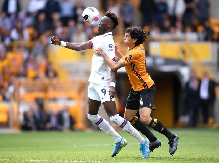 WOLVERHAMPTON, ENGLAND - SEPTEMBER 14: Tammy Abraham of Chelsea is challenged by Jesus Vallejo of Wolverhampton Wanderers during the Premier League match between Wolverhampton Wanderers and Chelsea FC at Molineux on September 14, 2019 in Wolverhampton, United Kingdom. (Photo by Laurence Griffiths/Getty Images)