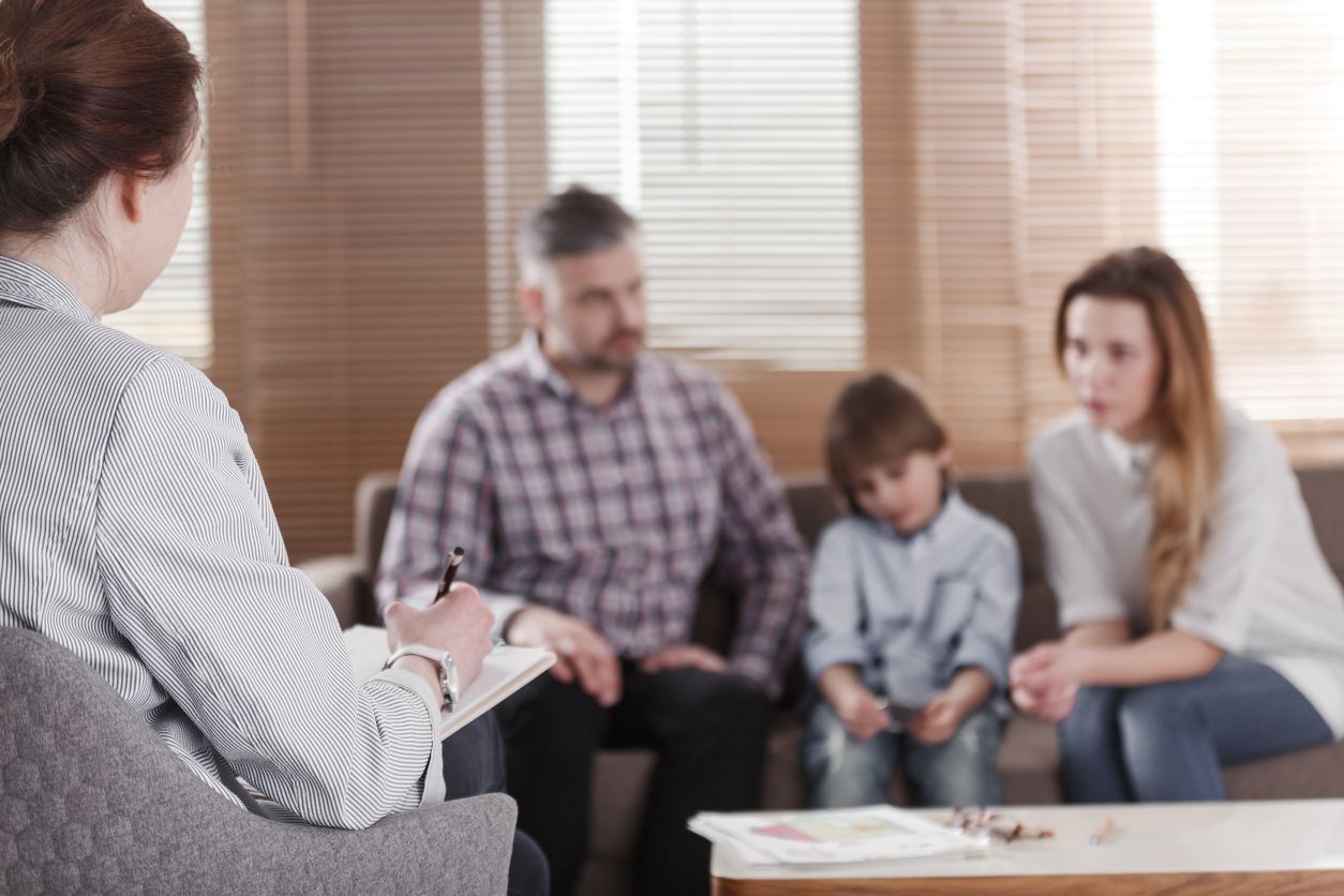 Speech therapist teaching a language an autistic child in an office