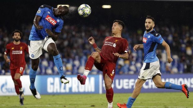 Napoli's Kalidou Koulibaly, left, heads the ball as Liverpool's Roberto Firmino tries to stop him during the Champions League Group E soccer match between Napoli and Liverpool, at the San Paolo stadium in Naples, Italy, Tuesday, Sept. 17, 2019. (AP Photo/Gregorio Borgia)