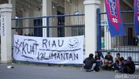 Sebuah kain putih bertuliskan Kuat Riau Kalimantan terpampang di pagar stadion.