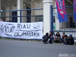 Sebuah kain putih bertuliskan Kuat Riau Kalimantan terpampang di pagar stadion.