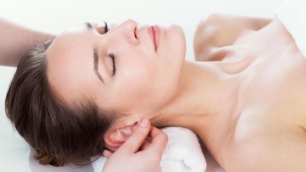 Young beautiful relaxing woman having a facial massage