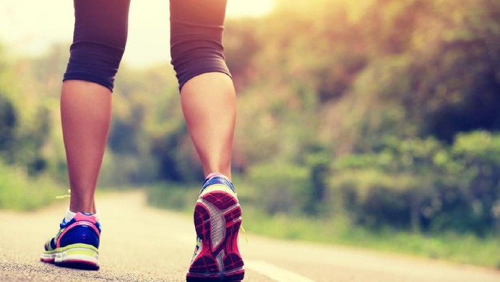 mengecilkan betis ilustrasi jalan kaki young fitness woman runner /hiker legs at forest trail