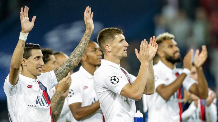 Paris Saint-Germains Argentine midfielder Angel Di Maria (L), Paris Saint-Germains Belgian defender Thomas Meunier (C) and teammates applaud and celebrate with supporters after winning at the end of the UEFA Champions league Group A football match between Paris Saint-Germain and Real Madrid, at the Parc des Princes stadium, in Paris, on September 18, 2019. (Photo by GEOFFROY VAN DER HASSELT / AFP)
