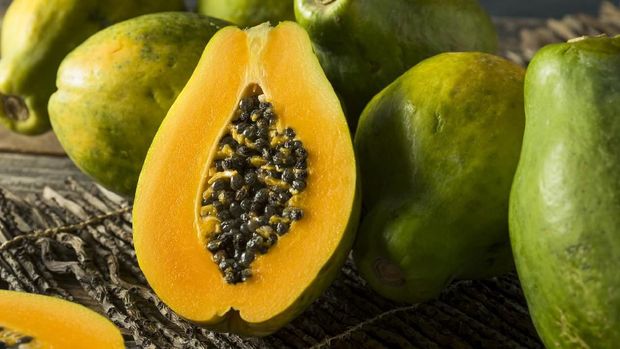 Papayas on display, with one cut in half to show the inside of the fruit, at the farmer's market in Honolulu, HI.