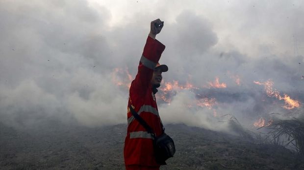 Petugas gabungan dari TNI dan Manggala Agni Daops Banyuasin  berusaha memadamkan kebakaran lahan di Desa Pemulutan, Ogan Ilir, Sumatera Selatan, Jumat (23/8/2019). Berdasarkan data dari Badan Penanggulangan Bencana Daerah (BPBD) Provinsi Sumatera Selatan periode Januari-Agustus sebanyak 1.675,80 hektare lahan yang terbakar di Kab/Kota yang ada di Provinsi Sumsel. ANTARA FOTO/Nova Wahyudi/nz