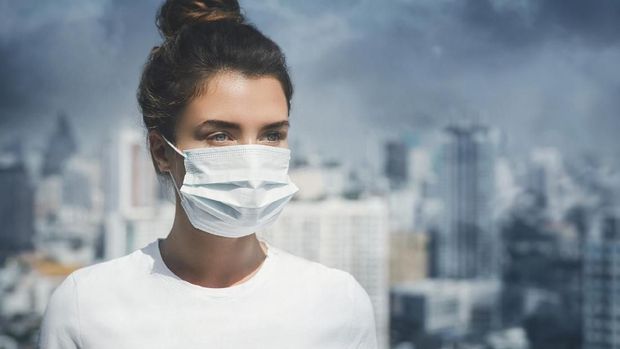 Woman wearing face mask because of air pollution in the city