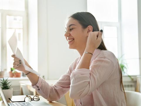 Happy young woman reading good news in paper letter, excited female student or employee receiving positive notification, successful exam results, deal, celebrating success or opportunity, new job