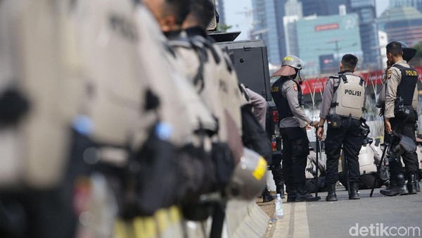 Sejumlah petugas kepolisian berpakaian lengkap bersiaga di depan gedung DPR. Pengamanan dilakukan terkait aksi demo yang akan digelar massa di depan gedung itu.