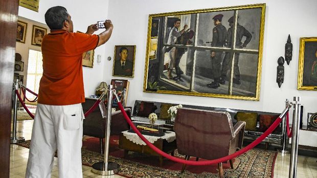 Pengunjung mengabadikan lukisan peristiwa pemukulan yang dilakukan Jenderal Ahmad Yani kepada anggota  Tjakrabirawa di Museum Sasmita Loka Ahmad Yani, Jakarta, Senin (30/9/2019). Museum yang awalnya merupakan rumah Jenderal Ahmad Yani itu merupakan saksi bisu peristiwa G 30 S/PKI yang menewaskan Jenderal Ahmad Yani. ANTARA FOTO/Muhammad Adimaja/ama.
