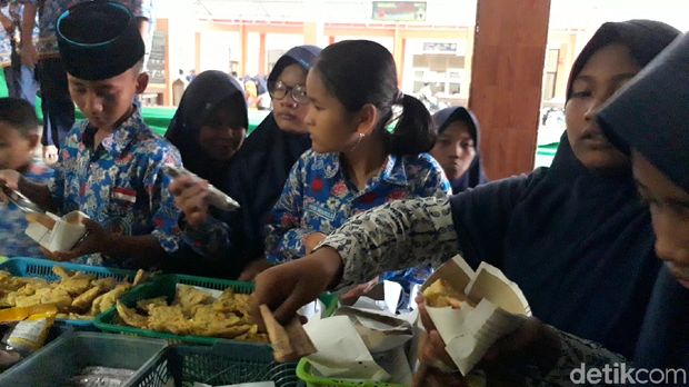 Siswa SMPN 1 Brebes makan menggunakan takir dari kertas.