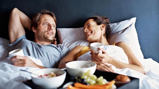 Shot of a mature couple relaxing in bed with breakfast