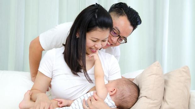 Indoor portrait of asian mother breastfeeding her baby