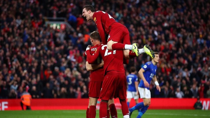 LIVERPOOL, ENGLAND - OCTOBER 05: James Milner of Liverpool celebrates with Jordan Henderson of Liverpool and Divock Origi of Liverpool and Andy Robertson of Liverpool  after he scores his sides second goal from the penalty spot during the Premier League match between Liverpool FC and Leicester City at Anfield on October 05, 2019 in Liverpool, United Kingdom. (Photo by Clive Brunskill/Getty Images)