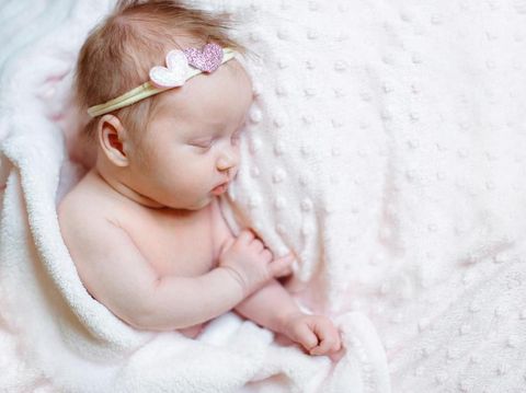 Newborn baby girl sleeping in a basket. Concept shooting newborns, innocence.